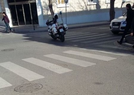 Yol polisi motosikletini piyada keçidinin üzərində saxladı